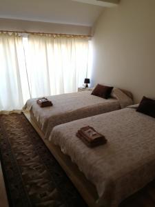 a bedroom with two beds and a window with curtains at Full Rooms in Kyustendil