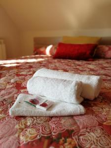una pila de toallas sentadas encima de una cama en Full Rooms en Kyustendil