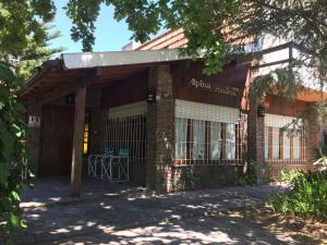 an entrance to a building with a gate at Alpina Hostería in Villa Gesell +19 photos