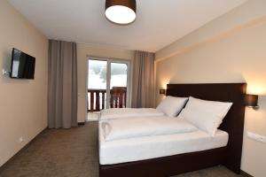 A bed or beds in a room at Hotel Studničky