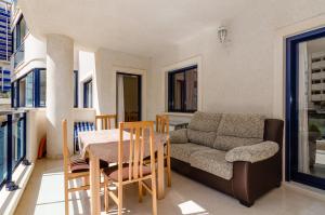 ベニドルムにあるComfortable apartment in Benidormのリビングルーム(ソファ、テーブル、椅子付)