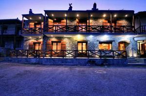 a large brick building with lights on it at night at Guesthouse Teloni in Vitina