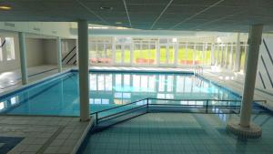a large swimming pool in a building at Amelander Kaap 101 in Hollum