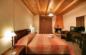 a hotel room with a bed, chair, and nightstand at Guesthouse Teloni in Vitina