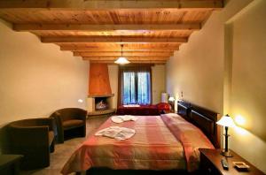1 dormitorio con 1 cama grande y techo de madera en Guesthouse Teloni en Vytina