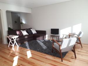 Una sala de estar con un sofá y un televisor. en Porto Nascente, en Oporto