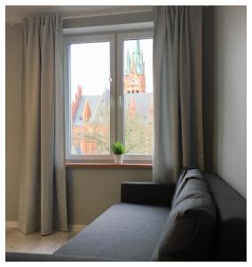 a bed in a room with a window at Apartament Mikołajek Stare Miasto in Toruń