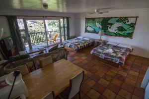 a living room with two beds and a table at Backpackers Vacation Inn and Plantation Village in Pupukea