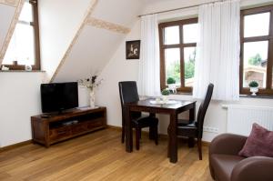 a living room with a table and a tv at Ferienwohnungen Holzmann in Buchholz Aller