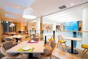 a restaurant with tables and chairs and a large window at Tenza Hotel & SKYSPA at Sapporo Central in Sapporo