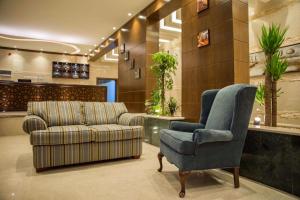 ein Wohnzimmer mit einem Sofa und einem Stuhl in der Unterkunft منازل الورد للشقق المخدومه Tabuk Risdance in Tabuk
