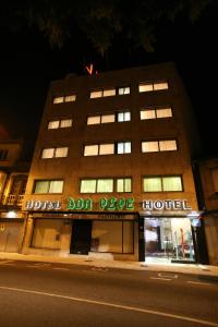 a building on the side of a street at night at Hotel Don Pepe in Poio