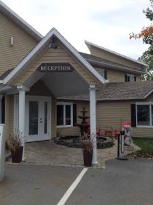 a house with a reception sign on the front of it at Motel Blanche d'Haberville in Saint-Jean-Port-Joli