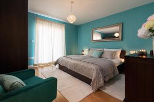 a bedroom with blue walls and a bed and a chair at Villa Kalura in Klanac +51 photos
