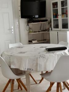 マルセイヤンにあるLe Calypsoの白いテーブル(白い椅子付)、テレビが備わります。