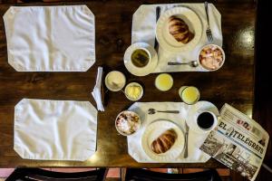 Apartamentos Los Quipus في كيتو: طاولة مع أطباق من الطعام وأكواب من القهوة