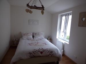 um quarto com uma cama com lençóis brancos e uma janela em les glycines em Cressonsacq