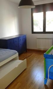 1 dormitorio con 1 cama, vestidor azul y 2 ventanas en Apartamento Paola. Prepirineo. Senderismo, relax..., en La Puebla de Castro