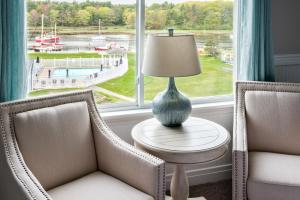 a living room with two chairs and a table with a lamp at The Nonantum Resort in Kennebunkport