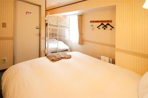 Un dormitorio con una gran cama blanca y una ventana en Hotel Prime inn Toyama, en Toyama