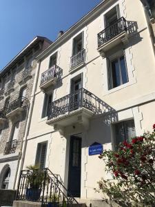 un edificio bianco con balconi sul lato di La Casa Cosy, Appart'Hôtel a Biarritz