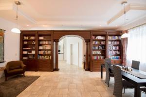 a living room with a table and chairs and book shelves at Ferienwohnung Mariazell - Hulatsch in Mariazell