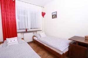 two beds in a room with a window at Willa Bona blisko Zamku Królewskiego i Rezerwatu Rzepka in Chęciny