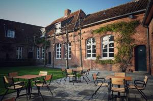 a patio with tables and chairs in front of a brick building at B&B Stillant in Gierle