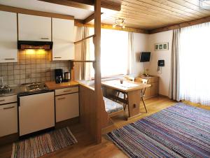 a kitchen with a counter and a table in it at Apartments Auenheim in Prägraten