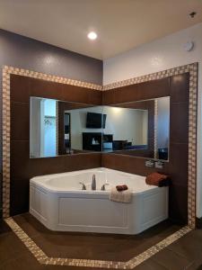 a large bathroom with a tub and a large mirror at Americas Best Value Inn - Brownsville in Brownsville