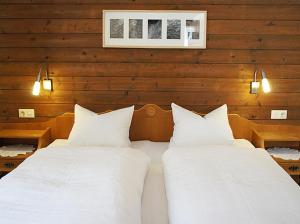 two beds in a room with wooden walls at Apartments Auenheim in Prägraten am Großvenediger