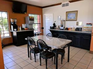 a kitchen with a table and chairs and a counter at Americas Best Value Inn - Brownsville in Brownsville