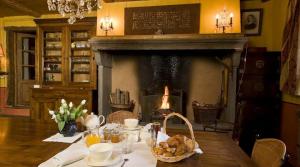 a table with a fireplace in a dining room at Chez l'Autre in Chilhac