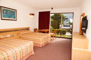 a hotel room with two beds and a flat screen tv at Hotel Paradise Inn in Ciudad Victoria