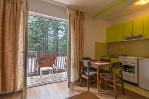 a kitchen with a table and chairs and a balcony at Mountain House Tara Apartmani Nikolic in Kaludjerske Bare