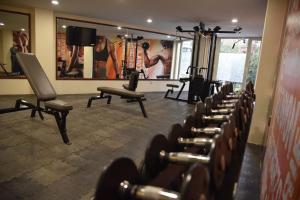a gym with a bunch of dumbbells in a room at Suites San Pedro in Zacatecas