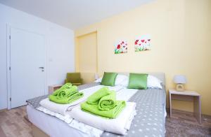 1 dormitorio con 1 cama con toallas verdes en Sunrise Inn Sarajevo, en Sarajevo