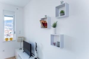 sala de estar con paredes blancas y TV en Sunrise Inn Sarajevo, en Sarajevo