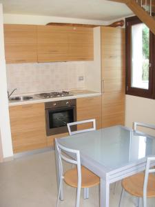 a kitchen with a table and chairs and a stove at Miramare Resort in Tirrenia