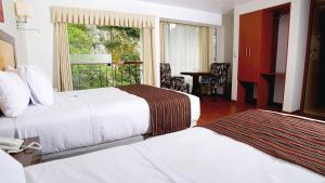 a hotel room with two beds and a window at Golden Sunrise Machupicchu in Machu Picchu