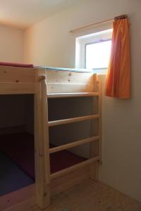 a bunk bed with a desk in a room at Agriturismo Mattei - Dormitorio in Peccia