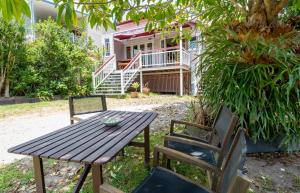 una mesa de madera y sillas frente a una casa en 99 Kirkland Bed & Breakfast, en Brisbane