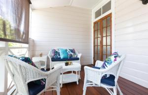 un porche con mesa y sillas de mimbre en 99 Kirkland Bed & Breakfast, en Brisbane