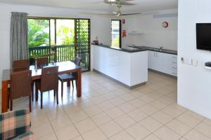 een keuken en eetkamer met een tafel en een televisie bij City Gardens Apartments in Darwin