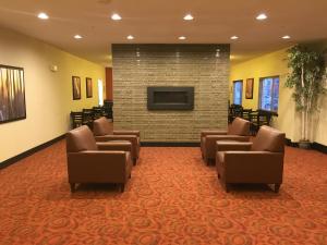 a waiting room with chairs and a flat screen tv at Aspen Hotel in Soldotna