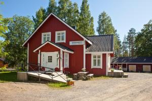 a red house with a white door on a dirt road at Holiday Club Hannunkivi Cottages in Kivijärvi