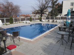 a swimming pool with chairs and a table next to it at Germanea Hotel in Sapareva Banya