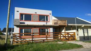 a house with a wooden fence in front of it at Apartamentos Croacia del Mar in Santa Clara del Mar
