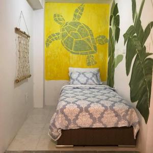 1 dormitorio con 1 cama con una pintura de tortuga en la pared en Hibiscus House en San Andrés