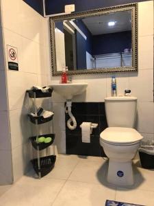 a bathroom with a toilet and a sink and a mirror at Hibiscus House in San Andrés